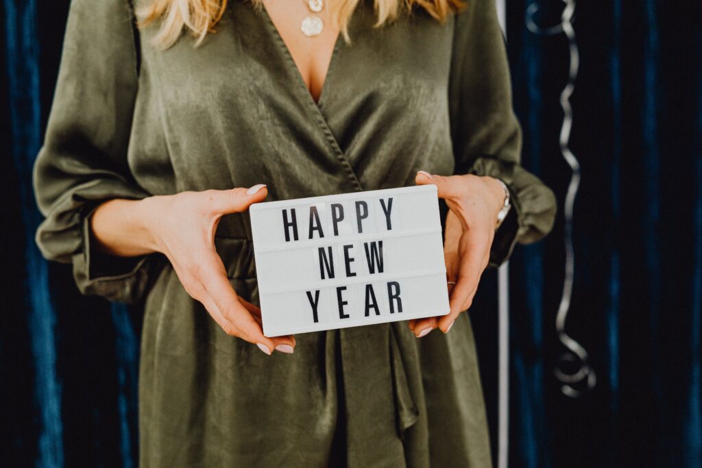 photo of a women holding a happy new year sign for our post about something to look forward to...