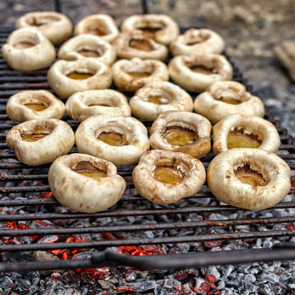 raw mushroom caps in griller