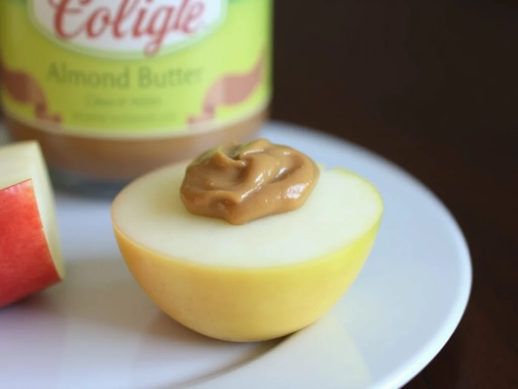 Half of an apple topped with a dollop of almond butter