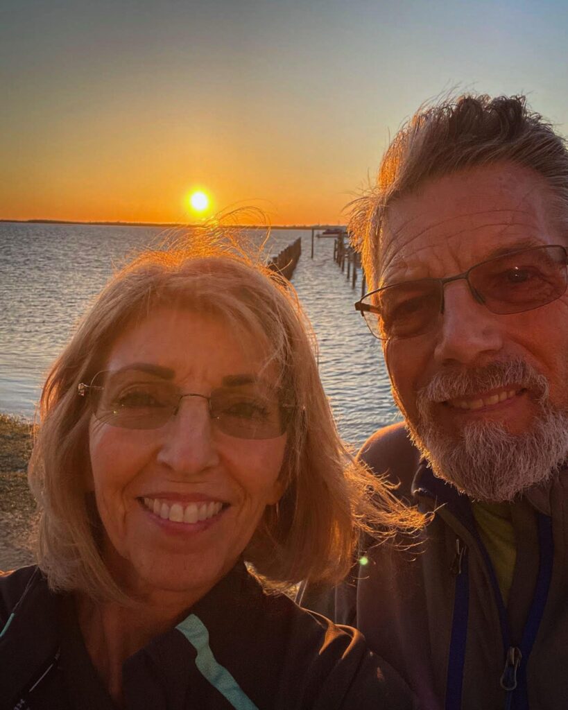 Lora and John Ulrich sharing a quiet sunset moment, partners in love, growth, and journey behind Son, Brother, Husband, Dad: Re-imagine Manhood, Rediscover You!