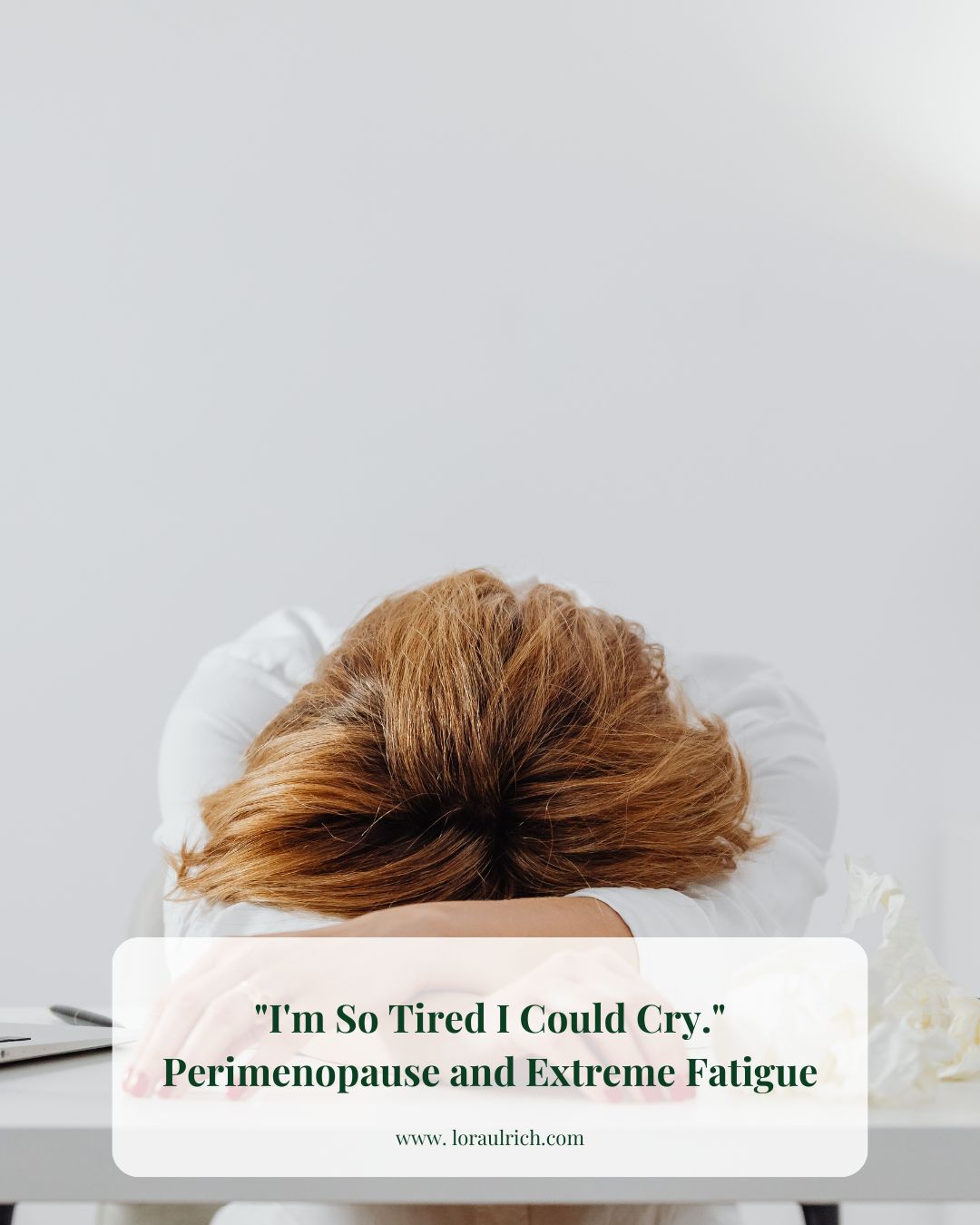 A midlife woman resting her head on a desk, visibly fatigued, capturing the emotional weight of perimenopause and extreme fatigue.