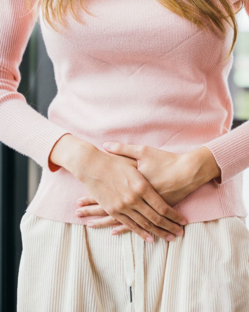 Woman with hands on stomach, illustrating reproductive health focus and midlife hormone changes.