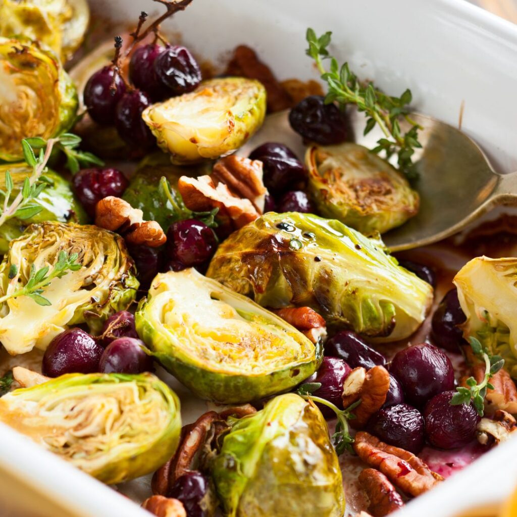 Holiday roasted Brussels sprouts with cranberries and toasted pecans on a serving platter.