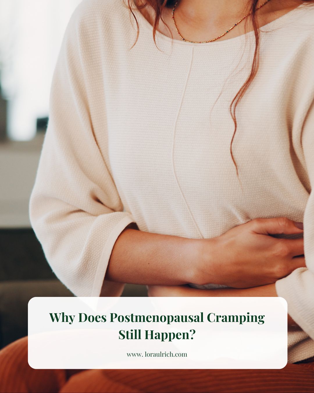 Midlife woman holding her stomach, illustrating postmenopausal cramping discomfort.