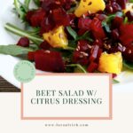 Colorful beet salad with citrus segments, leafy greens, and walnuts drizzled with light vinaigrette.