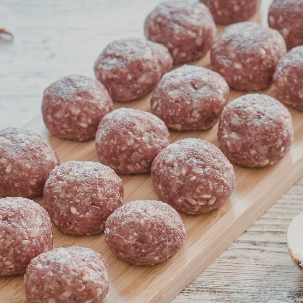Coconut balls recipe with cacao and tahini, with a rustic, textured surface showing flecks of coconut.