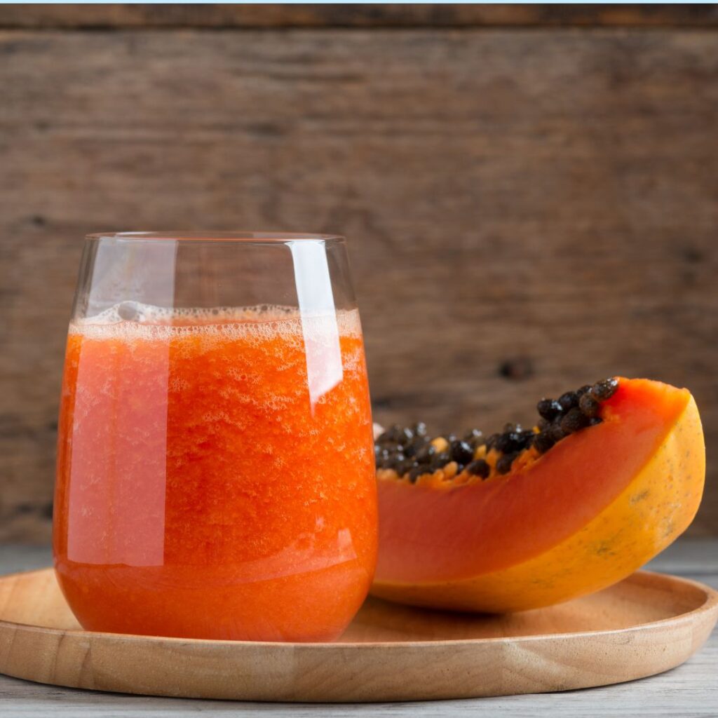 Creamy papaya smoothie made with almond milk and fresh papaya cubes, styled as a nourishing drink for digestion and menopause support.
