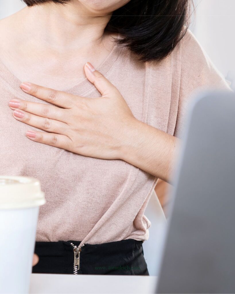 Concerned woman holding her heart, symbolizing perimenopause heart palpitations symptom.