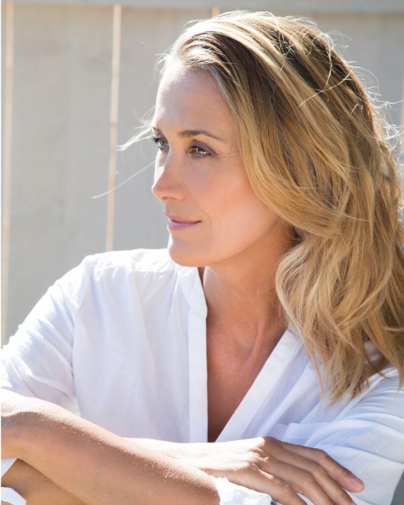 Midlife woman outdoors smiling confidently, symbolizing resilience and empowerment during perimenopause.