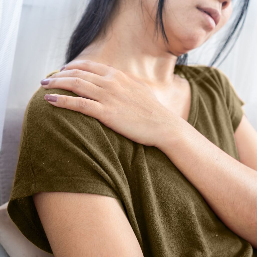 Woman holding shoulder in discomfort, showing perimenopause joints ache and stiffness.