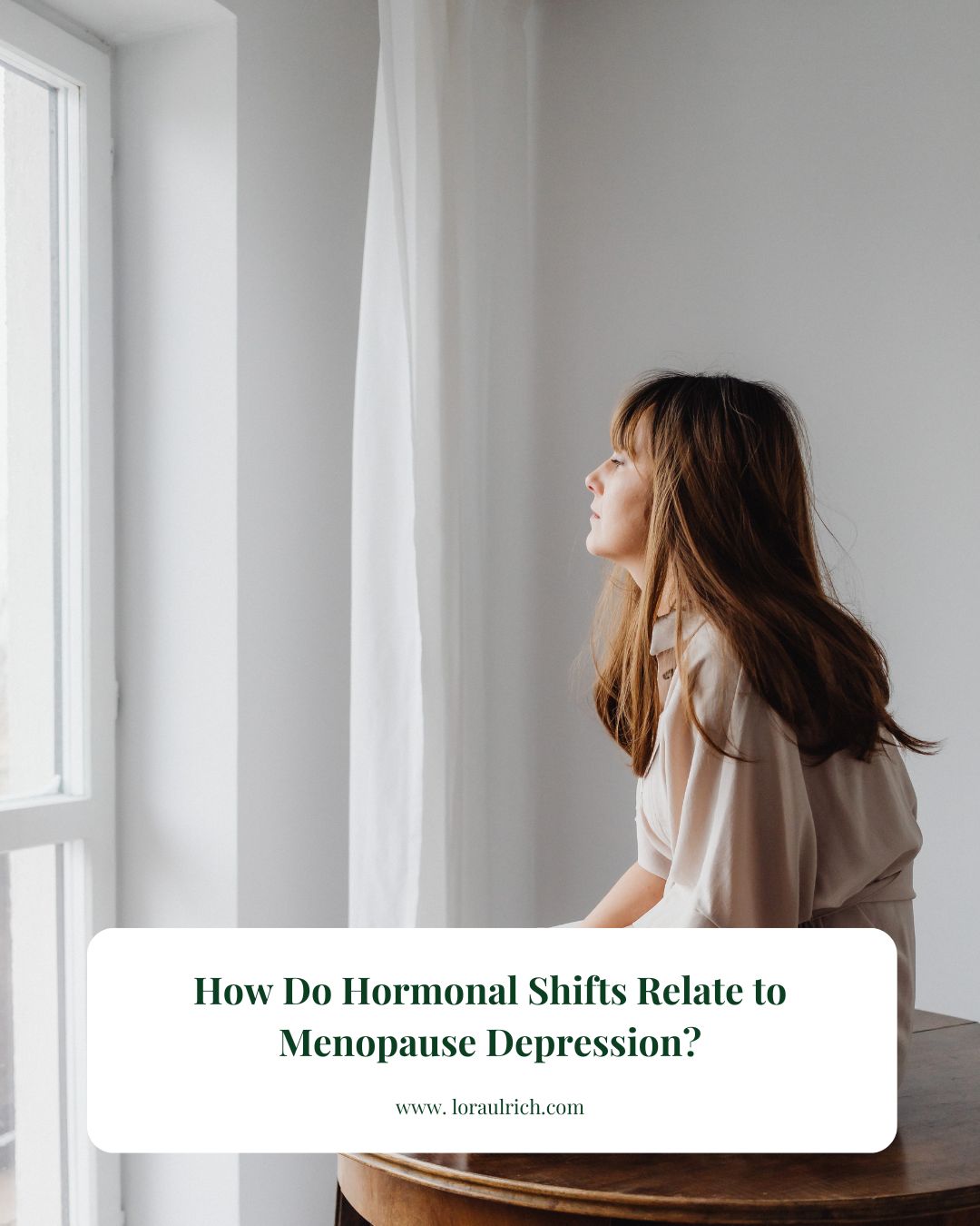 A woman sitting by the window in thoughtful reflection on hormonal health and menopause depression with guidance from a menopause health coach.