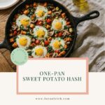 A cast iron skillet on a wooden table filled with a healthy sweet potato hash made of spring vegetables and crispy eggs.