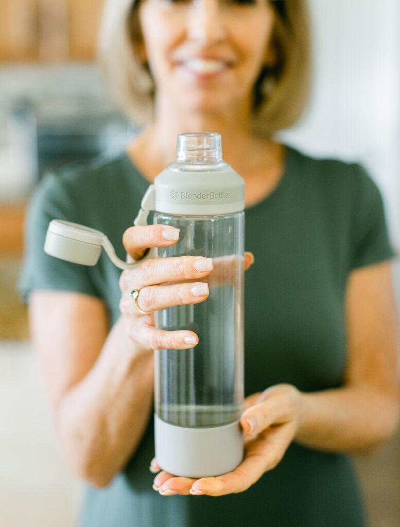Certified holistic nutritionist and metabolism specialist Lora Ulrich holding a water bottle, highlighting natural metabolism support and specialized menopause wellness programs.