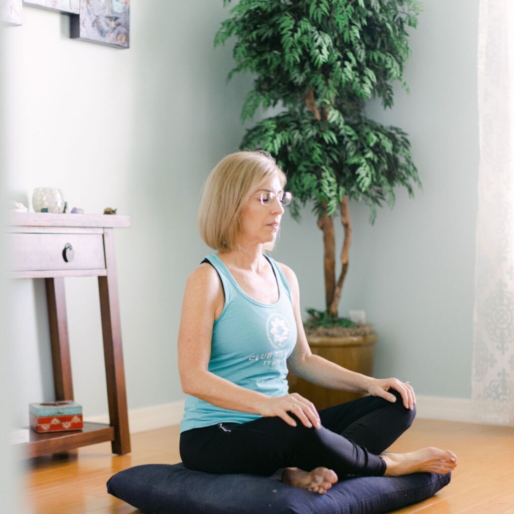 Menopause health coach Lora Ulrich practicing seated meditation to calm cortisol and support the nervous system during perimenopause